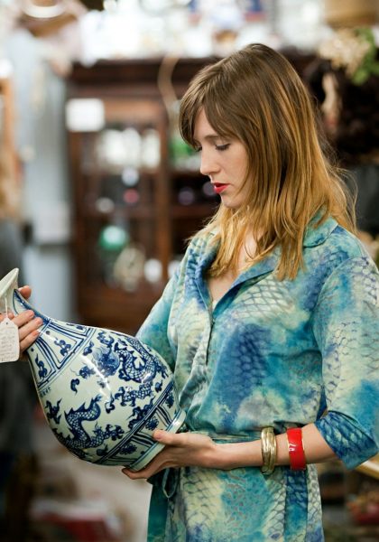Woman inspecting vase in antiques shop